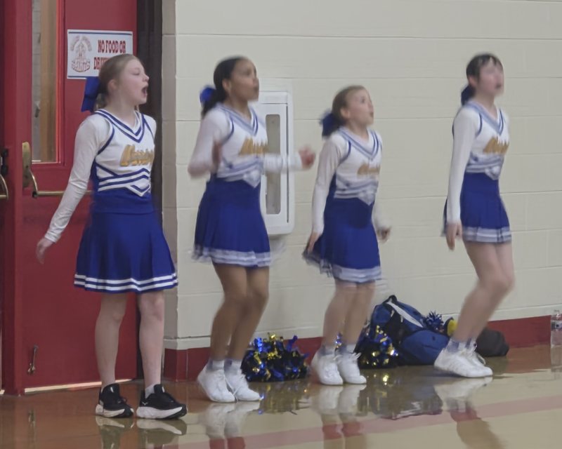 Decatur Christian cheerleaders cheering on the sideline at a basketball game