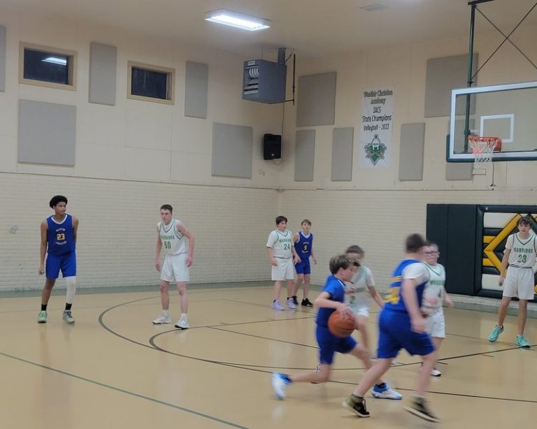 Decatur Christian players in blue bring the ball up the court during a basketball game