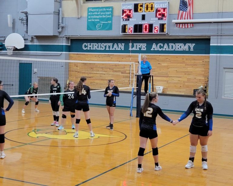 Decatur Christian volleyball teammates encourage each other during a tied match